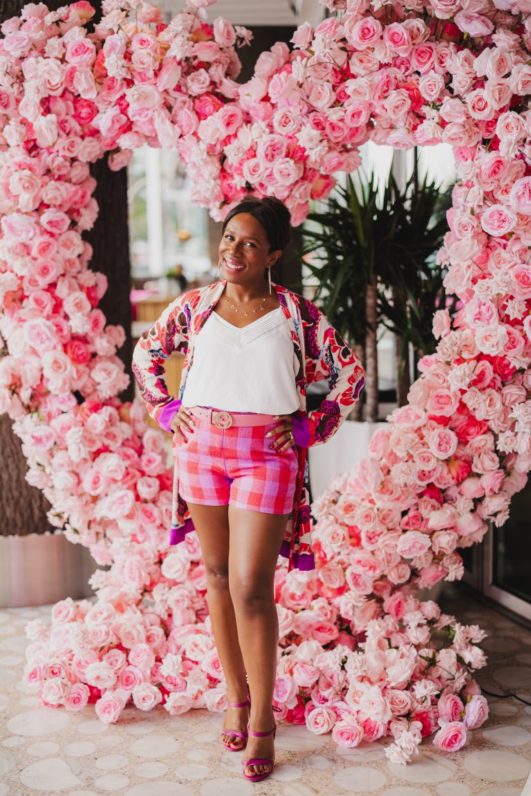 a woman standing in front of a flower arch