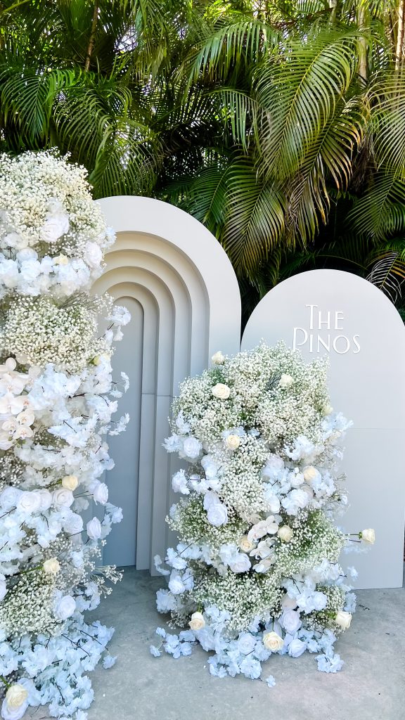 a group of white flowers next to a sign